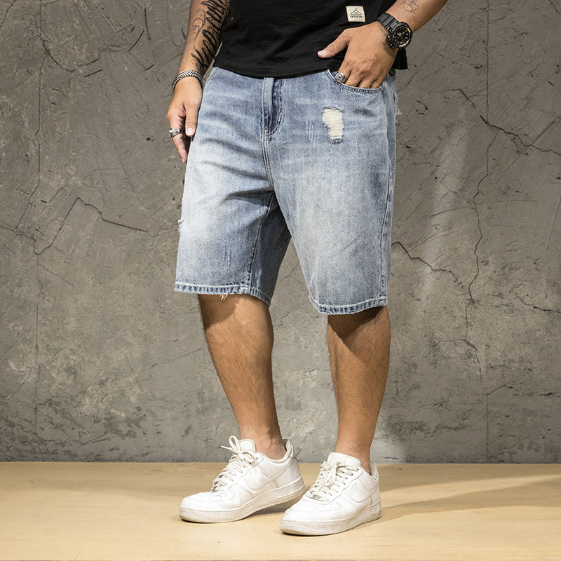 Casual men's relaxed fit distressed shorts with prominent ripped details, great for summer street style.