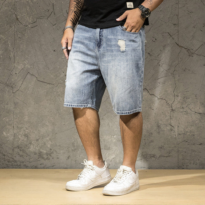 Casual men's relaxed fit distressed shorts with prominent ripped details, great for summer street style.