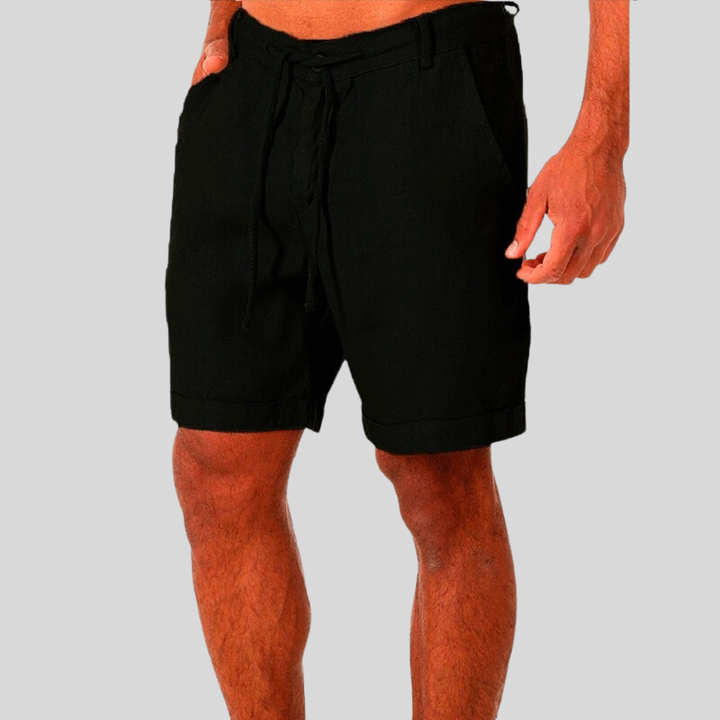 Man wearing versatile relaxed fit drawstring shorts, showcasing comfort & summer style for beach or weekend.