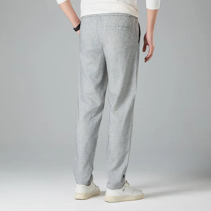 Detailed view of men's relaxed linen trousers, highlighting the comfortable drawstring waist.