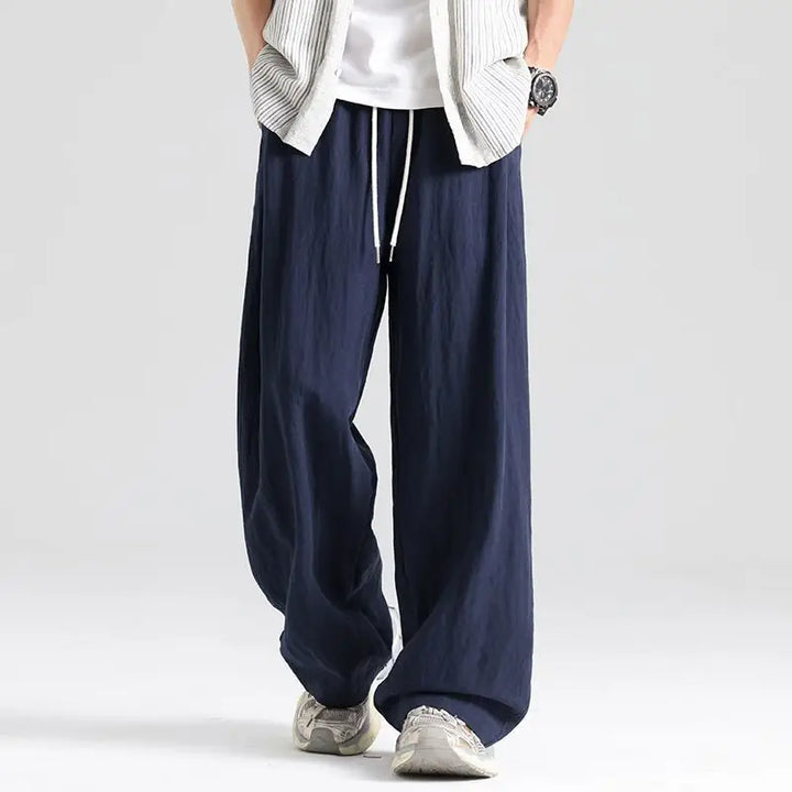 Men's relaxed fit linen wide leg trousers in a neutral color, ideal for casual summer style.