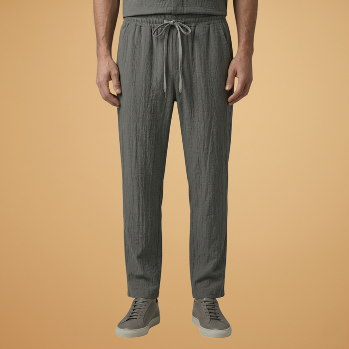 Coordinated men's two-piece ensemble: long sleeve top and relaxed fit drawstring trousers for summer comfort.