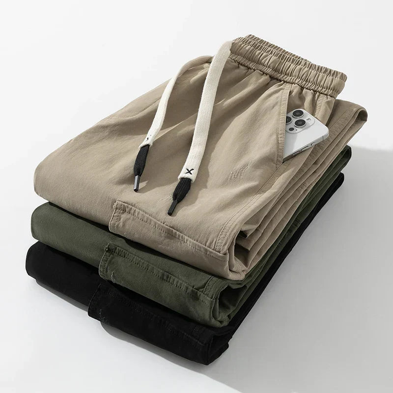 Close-up of men's wide leg cargo trousers, highlighting drawstring waist and utilitarian pockets.