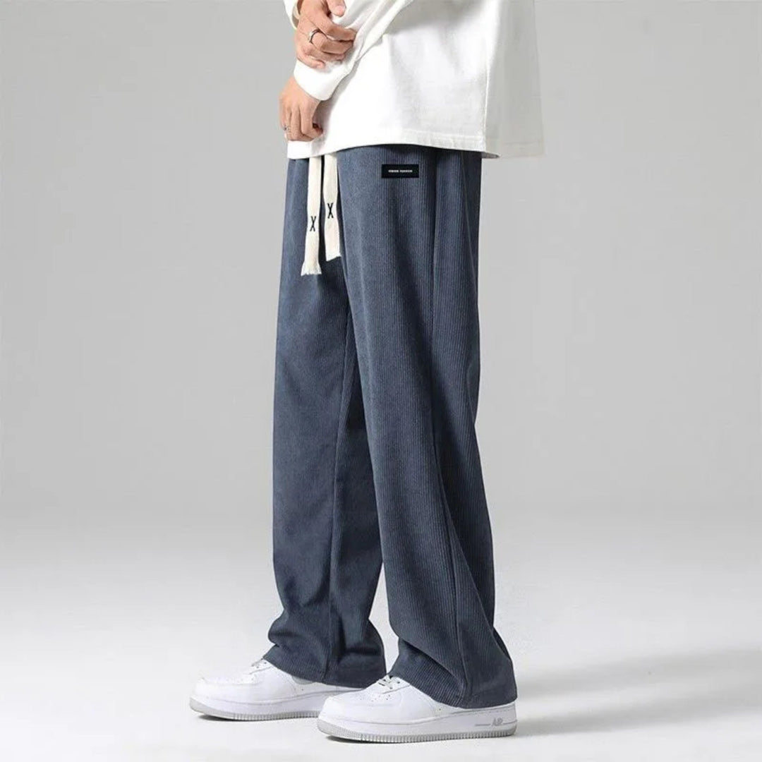 Man wearing comfortable sand relaxed fit wide leg sweatpants with drawstring, perfect for everyday style.