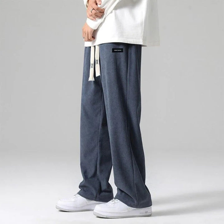 Man wearing comfortable sand relaxed fit wide leg sweatpants with drawstring, perfect for everyday style.