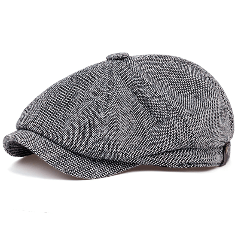 Close-up of men's herringbone flat cap fabric, showcasing detailed vintage pattern & tweed texture.