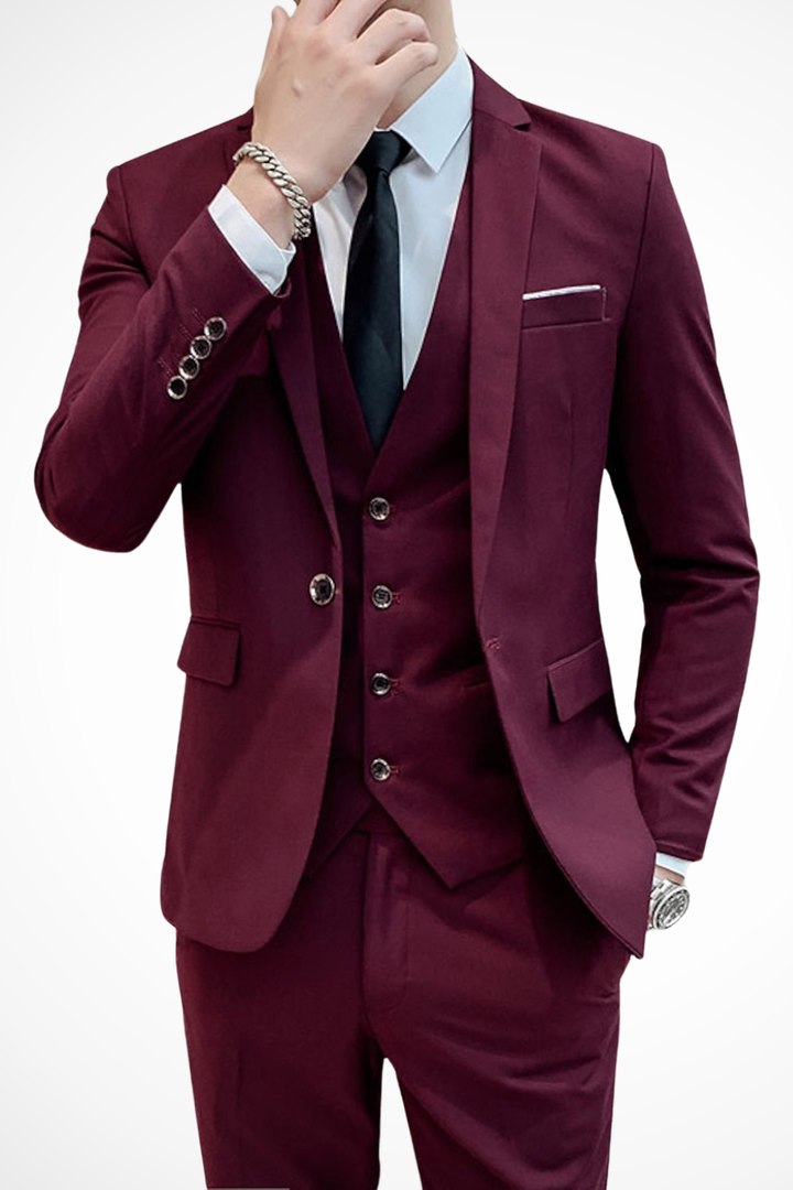 Full body shot of a man wearing a sharp black three piece suit for a wedding.
