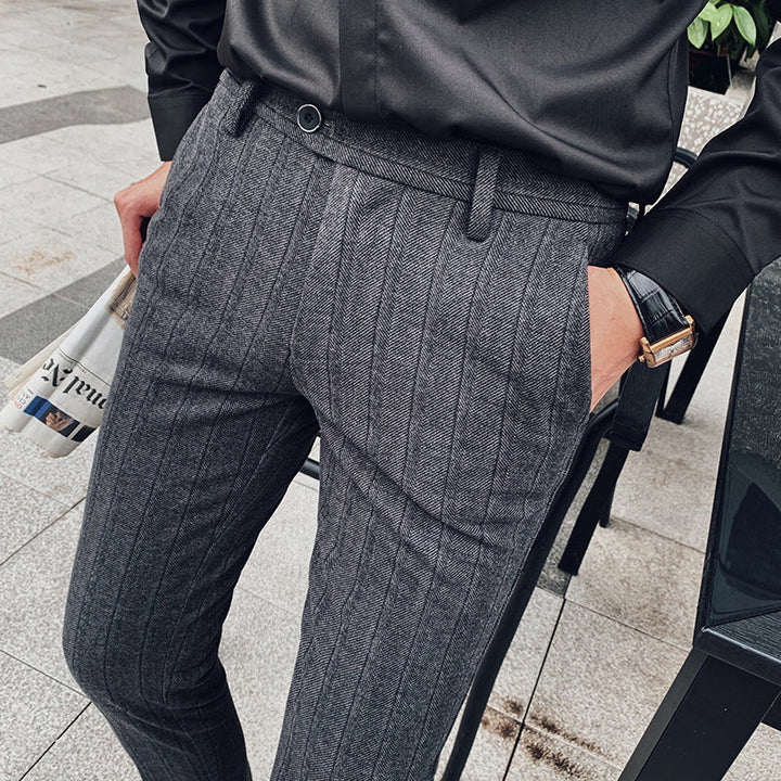 Close-up of modern men's slim-fit herringbone trousers in beige, showcasing professional texture.
