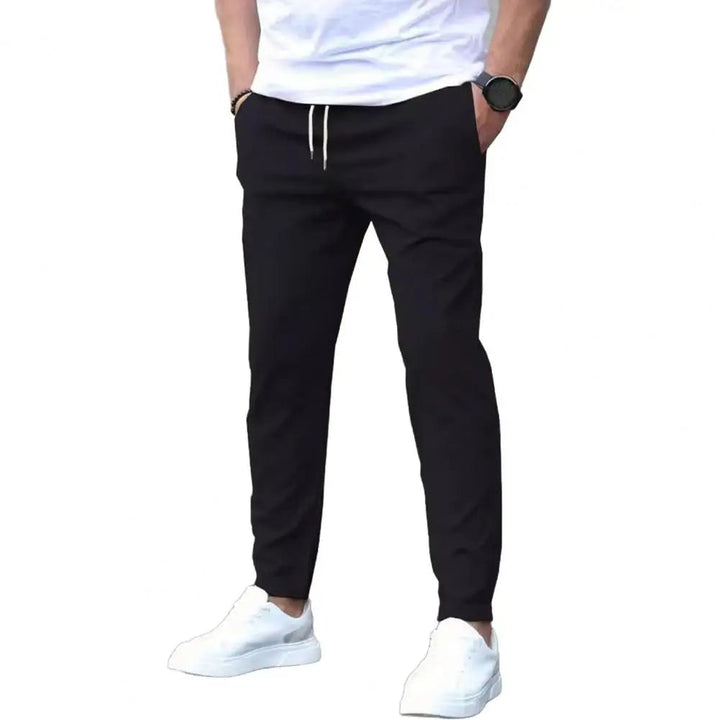 Full shot of men's sporty joggers, showcasing the elastic waistband, secure pockets, and athletic fit.