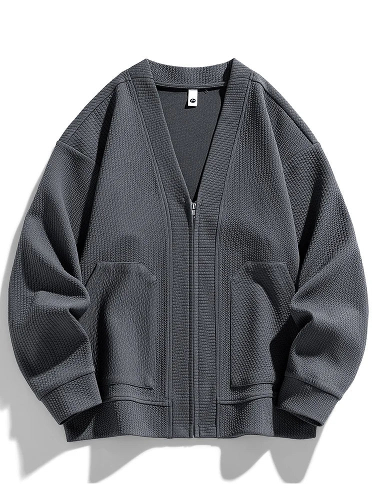 Close-up of the textured knit fabric on a men's zip cardigan.
