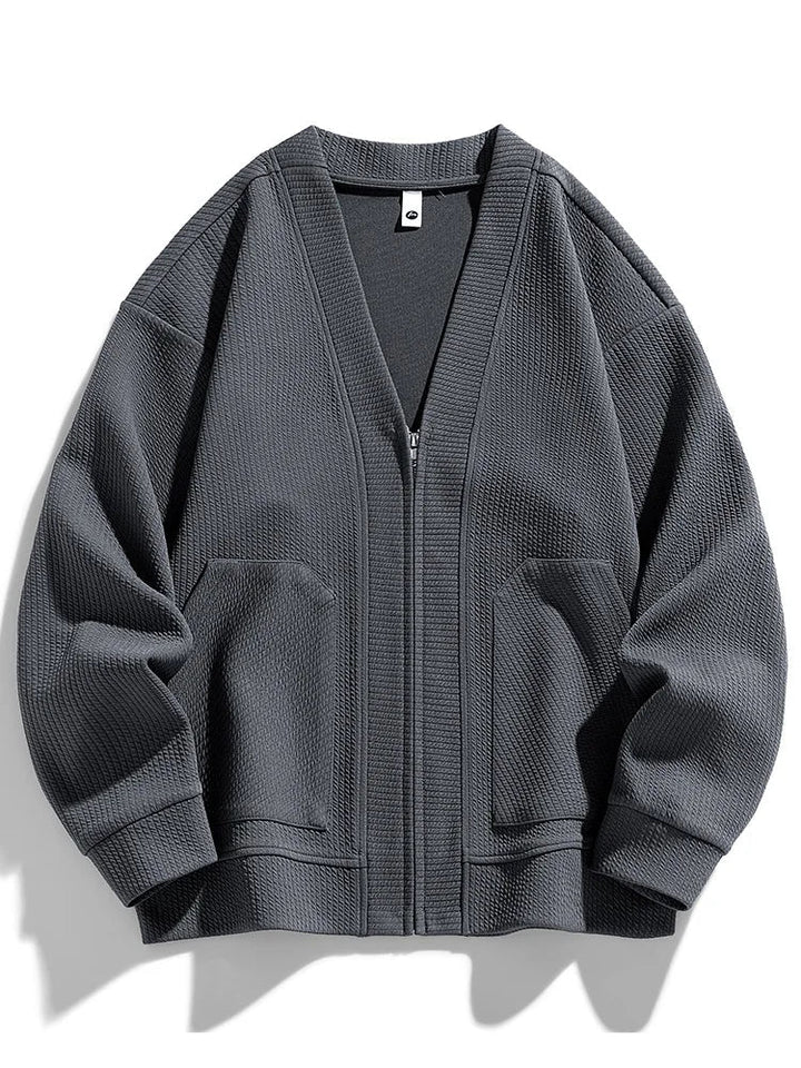 Close-up of the textured knit fabric on a men's zip cardigan.