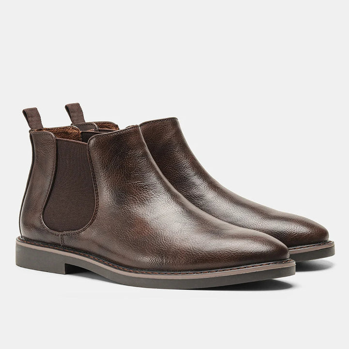 Close-up of stitching detail on stylish men's leather ankle boots, highlighting quality & fashion.