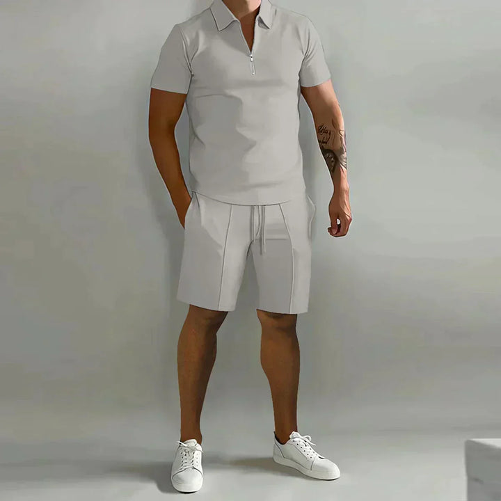 Man wearing a casual men's two-piece set with a zip-neck polo shirt and shorts, great for a summer fashion look.