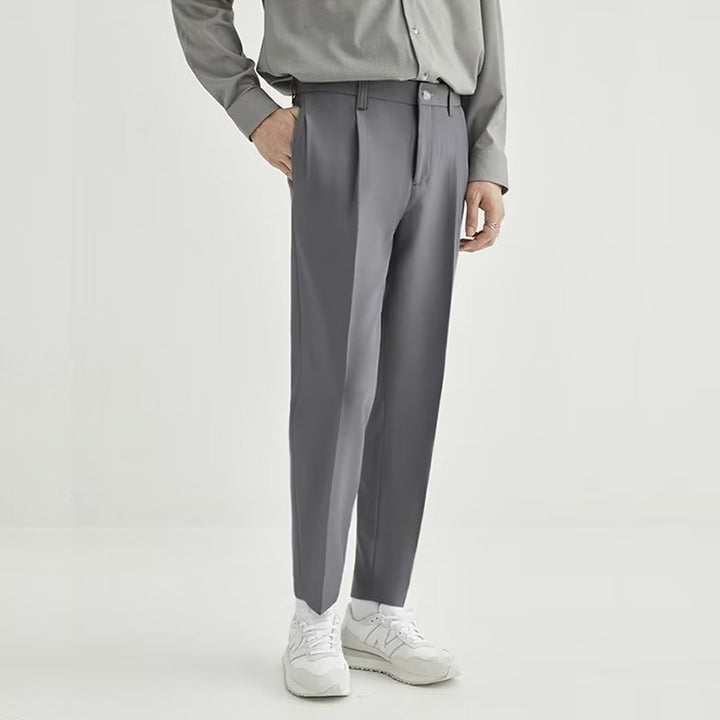 Detailed texture of men's high-waisted pleated cropped pants, perfect for smart casual and modern looks.
