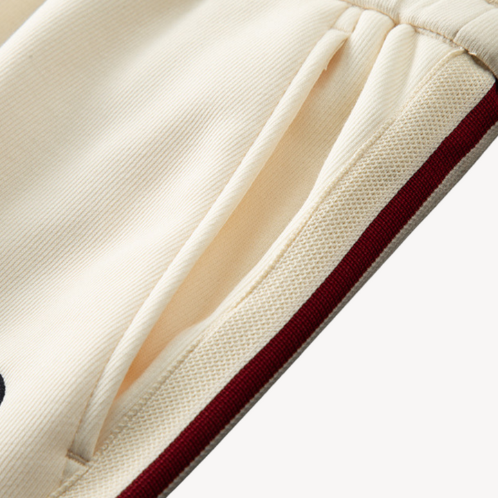 Side view of a men's athletic tracksuit, highlighting the fit of the zip hoodie & joggers for comfortable movement.