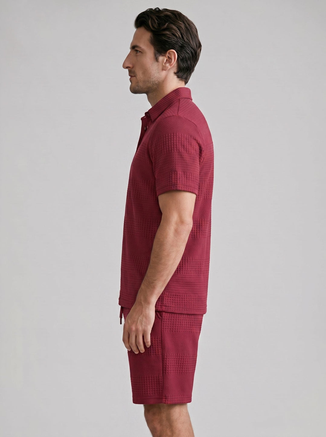 Close-up of men's textured polo shirt & shorts set fabric, showing knit detail.