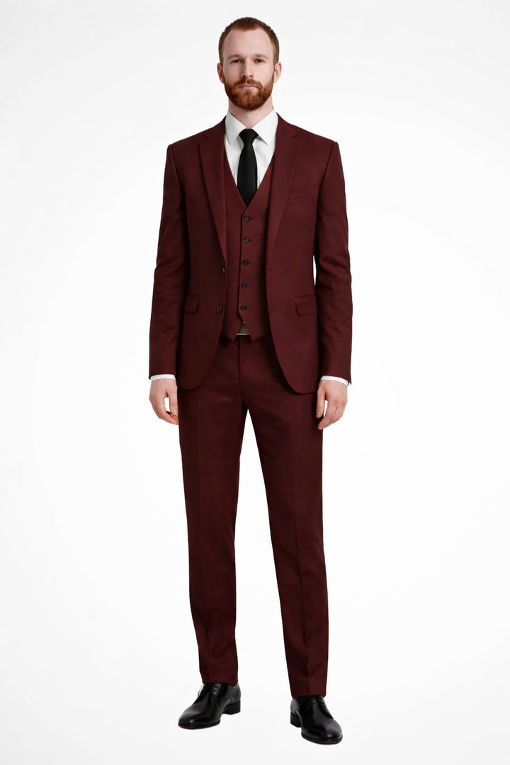 Full view of a man wearing a sharp navy three-piece suit for a wedding.