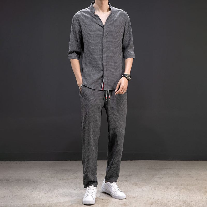 White men's linen V-neck shirt and drawstring pants, a comfortable two-piece outfit for breathable summer wear.