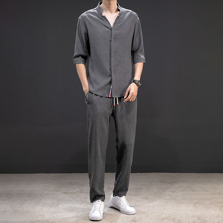 White men's linen V-neck shirt and drawstring pants, a comfortable two-piece outfit for breathable summer wear.
