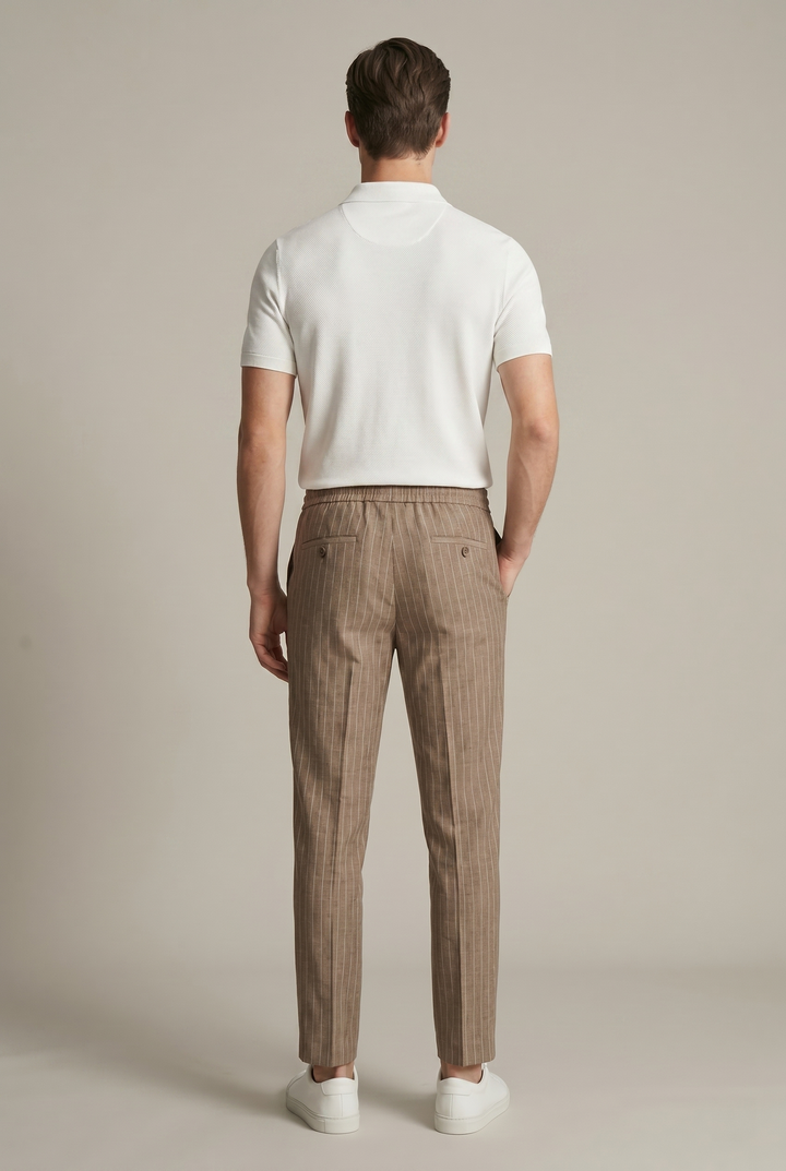 Comfortable men's tapered trousers featuring subtle vertical pinstripes and an elastic waist.