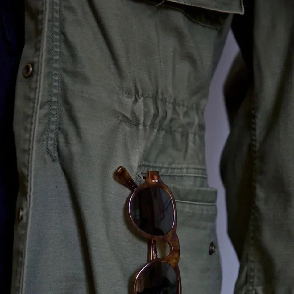 Rugged green men's vintage field jacket, perfect for layering, with an adjustable waist design.