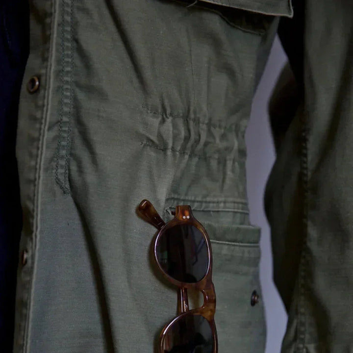 Rugged green men's vintage field jacket, perfect for layering, with an adjustable waist design.