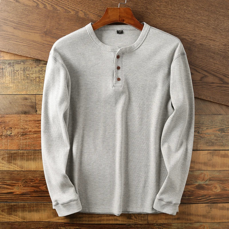 Close-up of textured waffle knit fabric on a men's long sleeve henley shirt