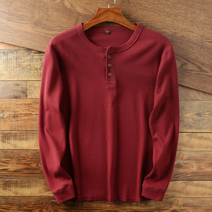 Stack of men's waffle knit henley shirts in various colors: blue, grey, black