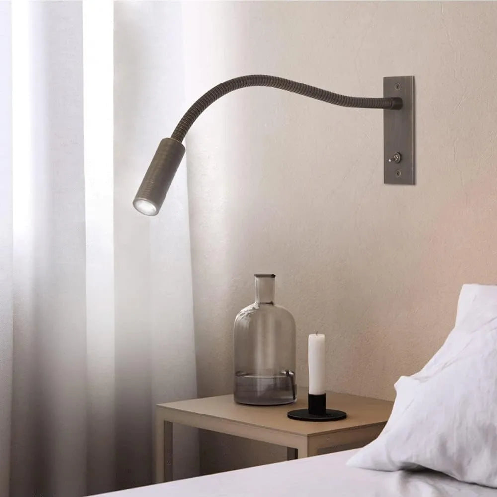 Modern metal wall lamp, adjustable spotlight, ideal for minimalist bedroom lighting and decor.