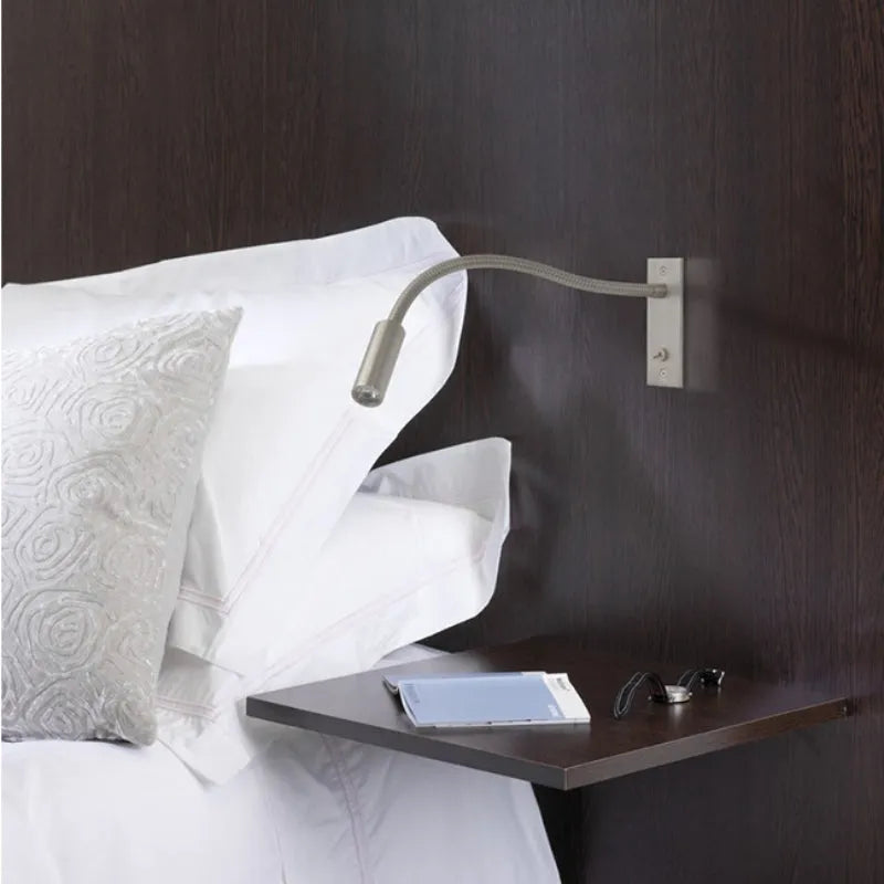 Adjustable minimalist wall lamp with LED spotlight, providing focused indoor reading light.