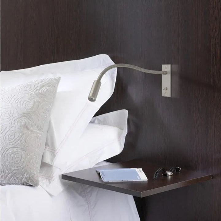 Adjustable minimalist wall lamp with LED spotlight, providing focused indoor reading light.