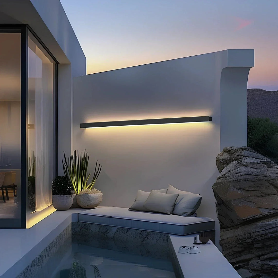Pair of modern LED outdoor wall sconces illuminating a home's facade at dusk.