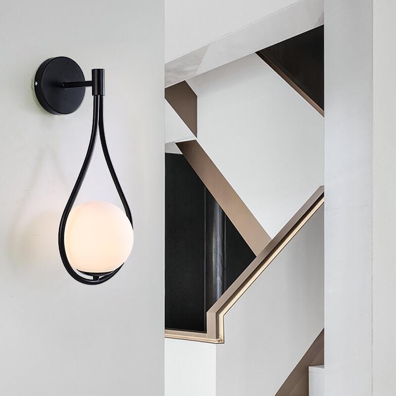 Sleek globe wall light with black and gold finish, perfect for hallways.