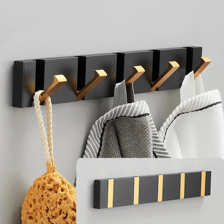 Modern black & gold foldable wall hook for entryway organization. Space-saving decor.