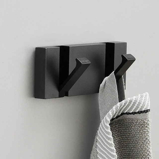 Black & gold foldable wall hook for bathroom, a space-saving towel hook with modern minimalist design.