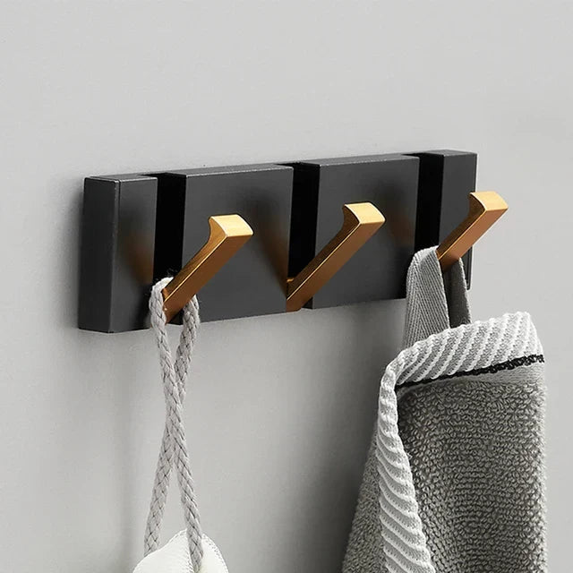 Versatile black & gold foldable wall hook, perfect for coats, hats, and towels. Modern style.