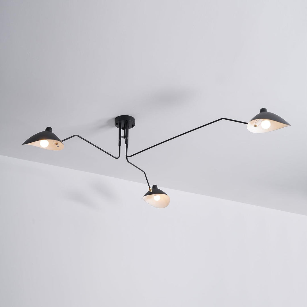 Dynamic lighting from an adjustable black multi-arm ceiling lamp.