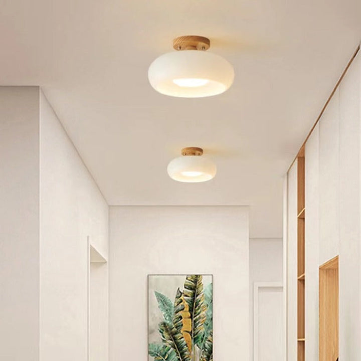 Contemporary flush mount ceiling light, LED compatible, with a stylish wood frame and glass shade.