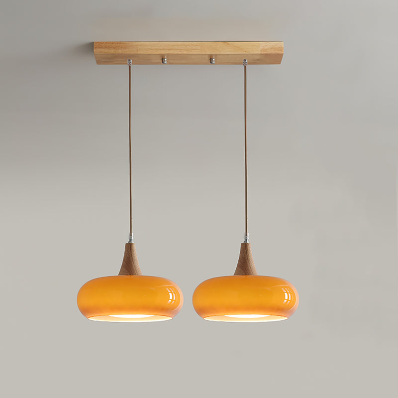 Elegant modern glass pendant light for dining areas, featuring natural wood details.