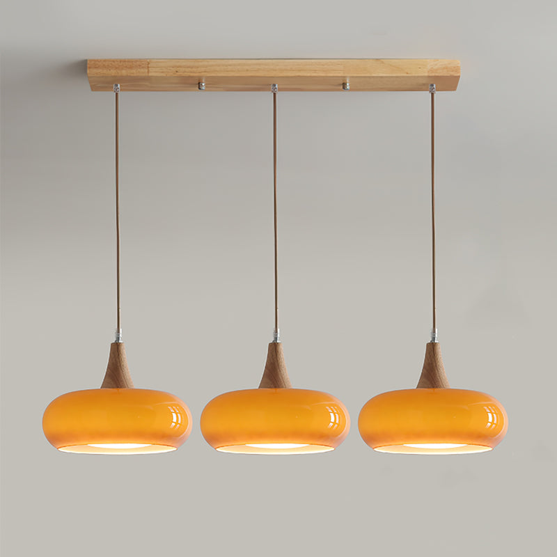 Bright modern glass pendant light with wood accents, perfect for illuminating dining.