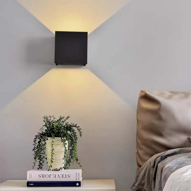 Minimalist square LED wall light, weather-resistant, provides ambient or accent outdoor illumination.