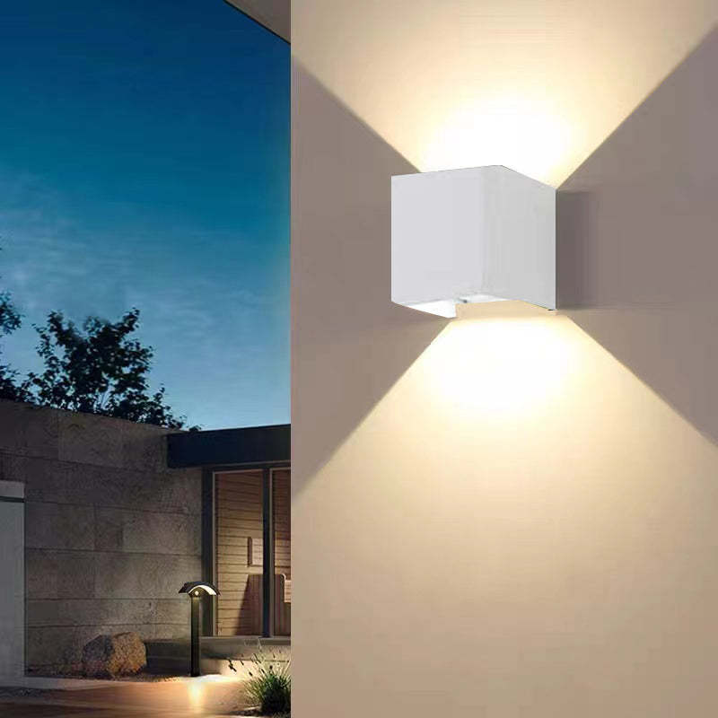 Modern square LED outdoor wall fixture, bright & efficient, illuminates entryways and gardens.