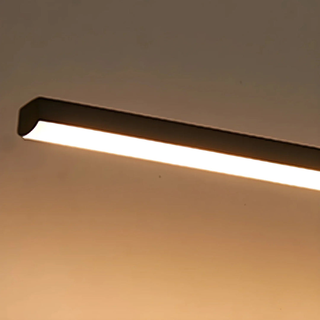 Gold hardwired linear LED vanity lamp; modern design for elegant bathrooms.