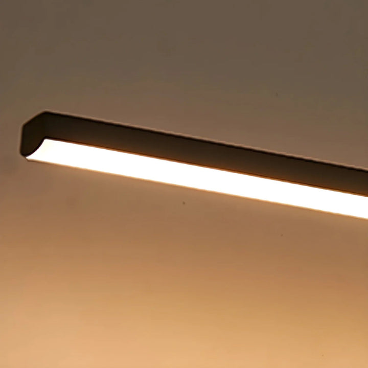 Gold hardwired linear LED vanity lamp; modern design for elegant bathrooms.