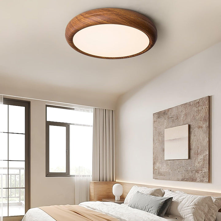Modern LED ceiling fixture, round, flush mount, wood grain, provides ambient light.