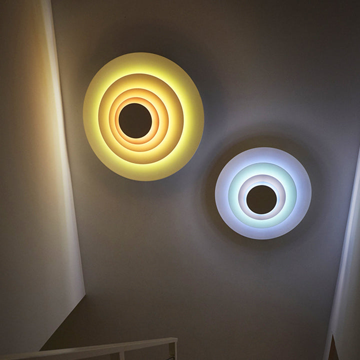 Pink modern round LED wall light, ideal for contemporary bedroom accent lighting.