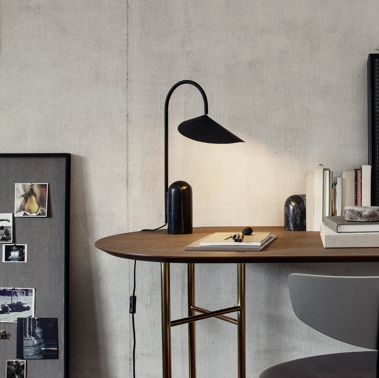 Modern black table lamp, sculptural, arched form, and a striking marble base.