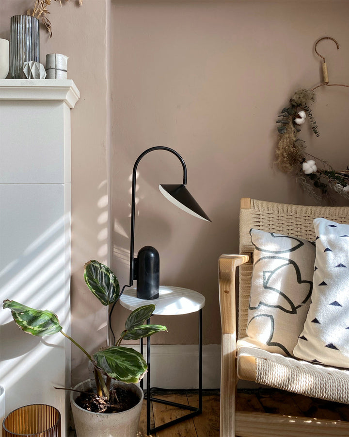 Living room lamp, black, modern, arched, with a distinctive marble base.