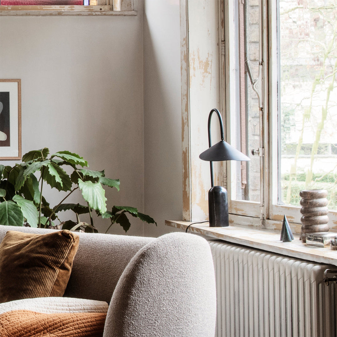 Accent light, beige, contemporary table lamp with a distinctive arch & white marble base.