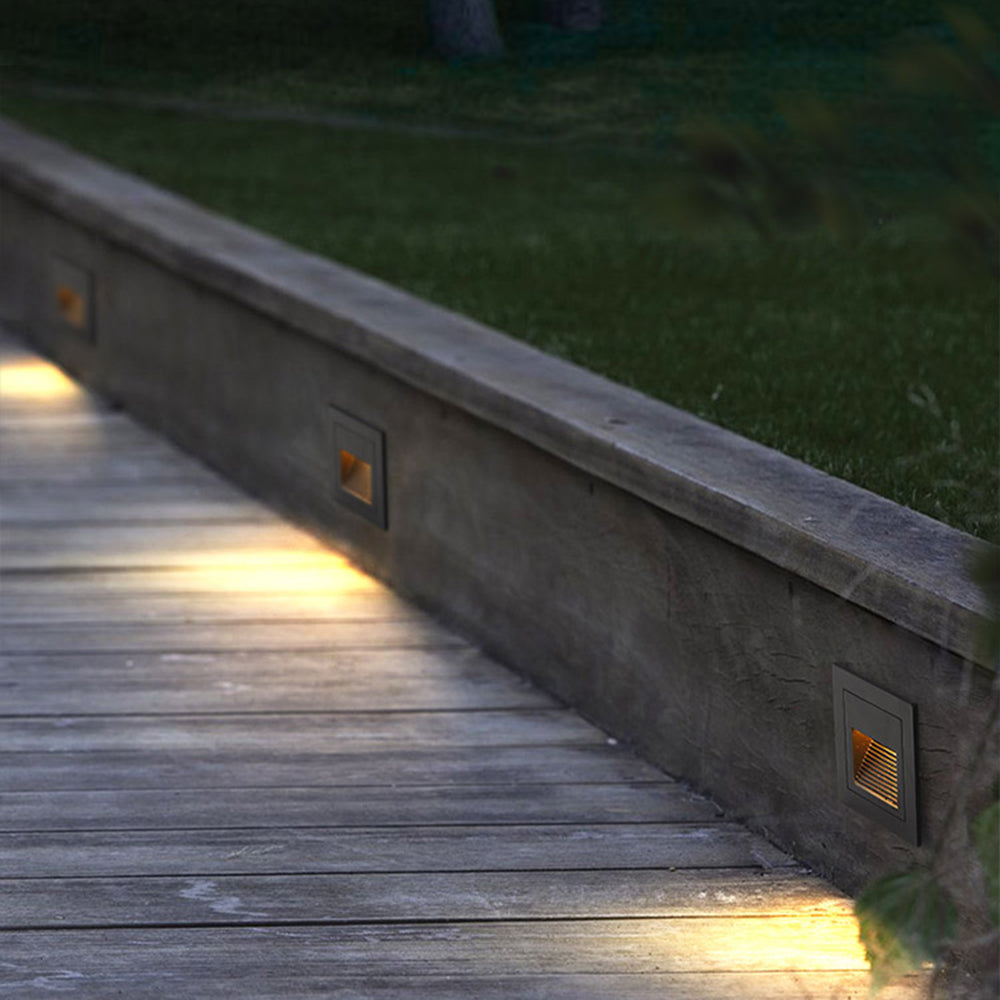 Contemporary square LED deck light, enhancing outdoor steps & pathways.